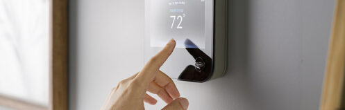 Woman adjusting the thermostat