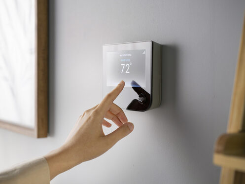 Woman adjusting the thermostat